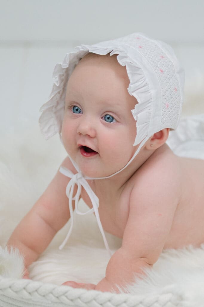 Baby girl wearing a bonnet for her session with baby photographer in Bainbridge