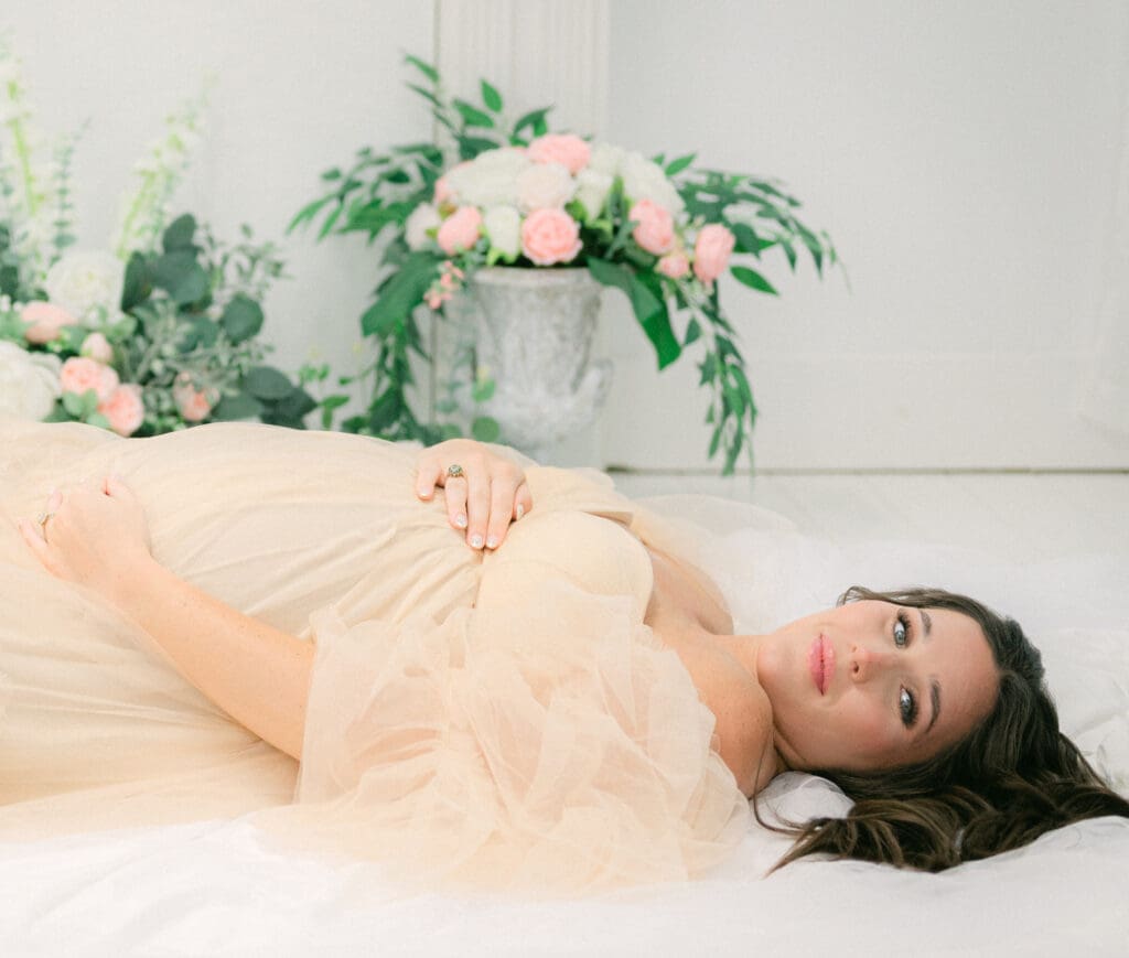 Maternity portrait of a pregnant woman laying in a peaceful pose on the floor
