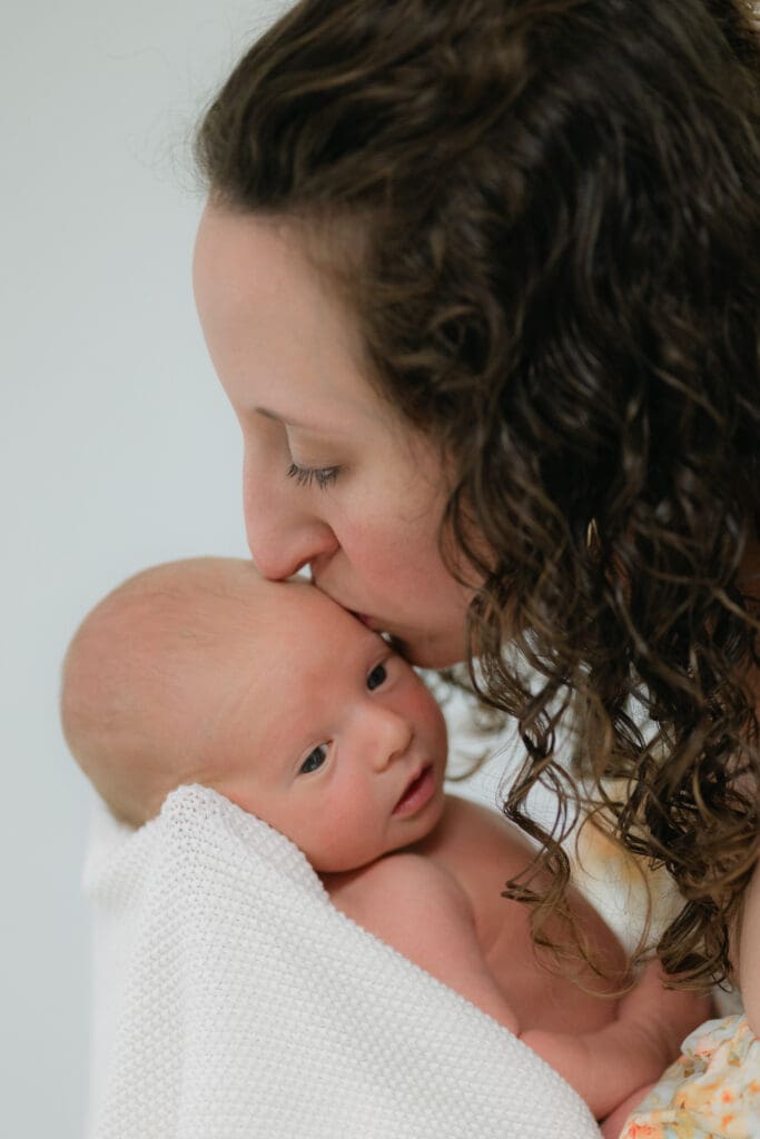 Close-up of a mother kissing her newborn baby gently