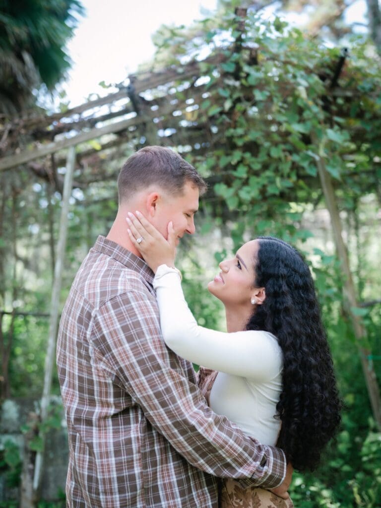 Couple smiling at each other during anniversary session in the garden