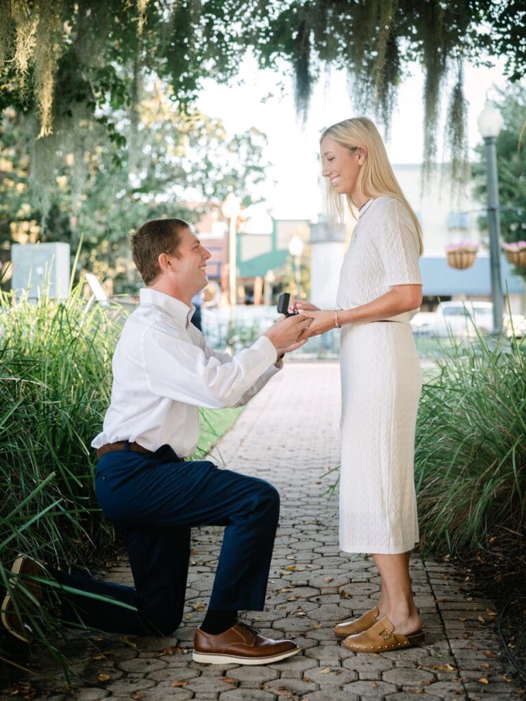 Groom down on one knee proposing to his girlfriend in Bainbridge