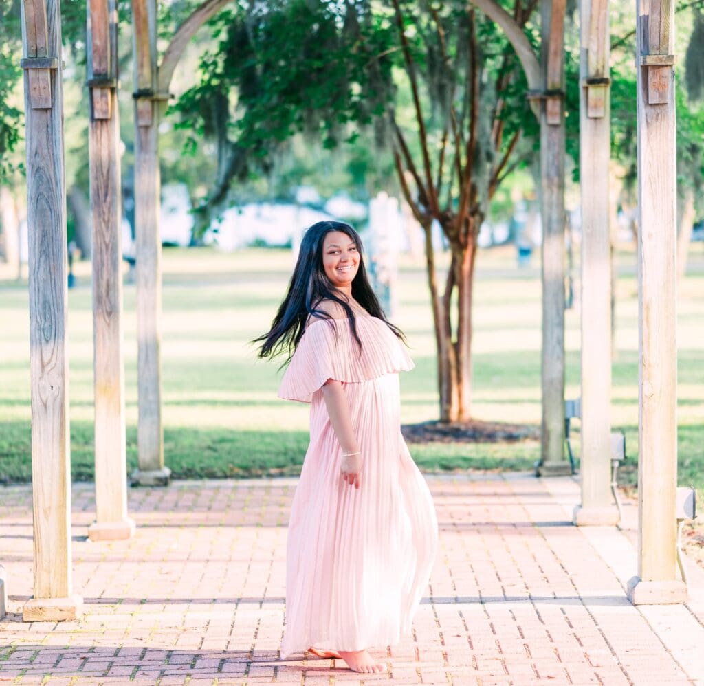 Full length senior portrait in Bainbridge GA of girl twirling and dancing in a garden