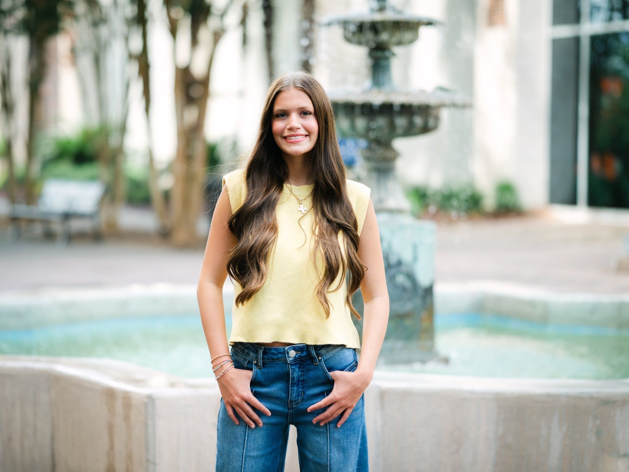 High school senior standing in front of a fountain during her portrait session in Tallahassee, Florida